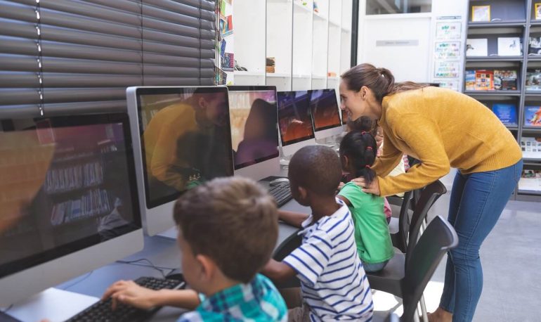 teacher-teaching-schoolgirl-in-computer-room-LRBVPFQ